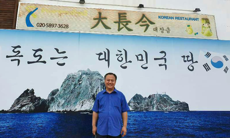 Youn Jae-wouk owns four Korean restaurants in Vientiane, the capital of Laos. He is pictured here standing in front of one his restaurants with a large sign on the wall reading 